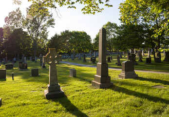 Old cemetery at sunset, with crosses in the foreground and green grass. Halifax, Nova Scotia,...