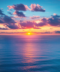 Fototapeta premium A breathtaking scene featuring a vibrant blue sky with white clouds and a golden sunset reflecting on the sea, captured in high-definition photography with rich colors and radiant golden light