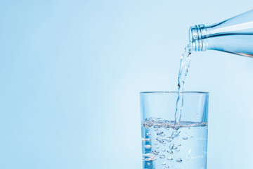 Crystal clear water being poured into a transparent glass, creating refreshing ripples and bubbles