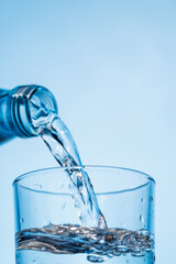 Crystal clear water being poured into a transparent glass, creating refreshing ripples and bubbles