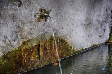 Water flows out of the old faucet in a village