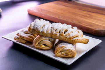 Delicious homemade cakes. Puff pastry with cherries, generously sprinkled with icing sugar on top. Delicious fresh buns close up view