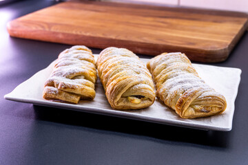 Delicious homemade cakes. Puff pastry with cherries, generously sprinkled with icing sugar on top. Delicious fresh buns close up view