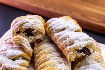 Delicious homemade cakes. Puff pastry with cherries, generously sprinkled with icing sugar on top. Delicious fresh buns close up view