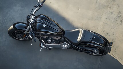 A black and silver motorcycle with a white seat and gold accents, parked on a concrete surface with a blue sky in the background.