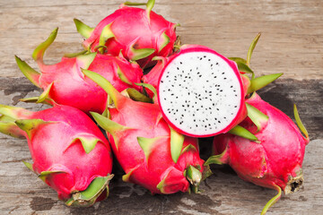 Ripe red dragon fruit on old wooden table background