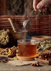 Cup of herbal tea with various dried herbs, flowers, and spices.