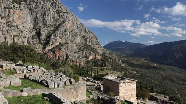 The Athenian Treasury from Delphi Archaeological Site. Wide 4k video with this historical cultural construction from Delphi, part of Greek history. Photo during a sunny day. Travel to Greece.
