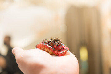 Japanese Omakase meal. Aging raw Akami tuna sushi add with sliced truffle served by hand and place on a customer palm. Japanese luxury meal.