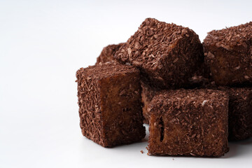 Delicious dark chocolate cubes stacked on a white background ready to be enjoyed as a sweet treat or dessert