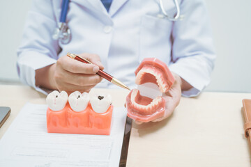 Male doctor treating dental diseases at a hospital, discussing tooth decay, crooked teeth broken...