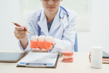 Male doctor treating dental diseases at a hospital, discussing tooth decay, crooked teeth broken...