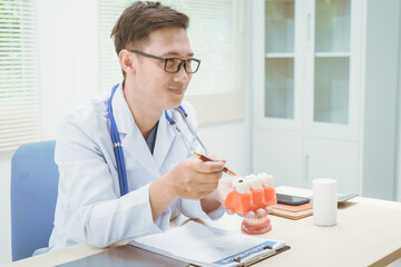 Male doctor treating dental diseases at a hospital, discussing tooth decay, crooked teeth broken...