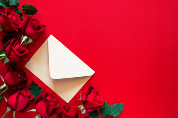 An envelope with red roses put on red background for Mother and Valentine's day concept.