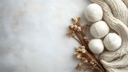 White yarn balls, knitted scarf, dried flowers on marble; cozy autumn crafting scene, ideal for blog or website header