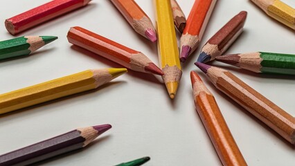 Close-up of scattered colorful pencils on white surface