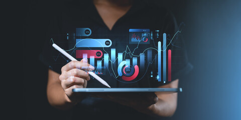 Person interacting with digital financial graphs and charts on a tablet.