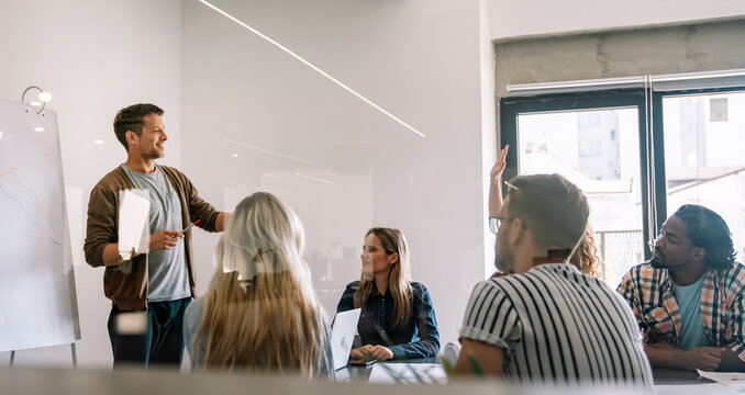 Smiling diverse colleagues gather in boardroom brainstorm discuss financial statistics together