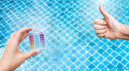 Mini tester in girl hand with thumbs up hand over clear swimming pool water background, good...