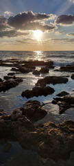Obraz premium Relaxing sea waves at sunset near rocky coast