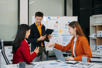 Group of professionals participating in meeting or workshop. presenter standing near flip chart give presentation interact with participants, attendee ask questions, share opinion or solutions.