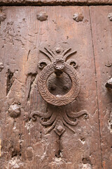 Vintage wooden door with trim ornaments and beautiful door knocker