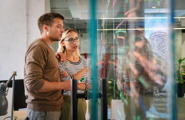 Obraz premium Group of young multi-ethnic startup business team collaborating on project in modern office