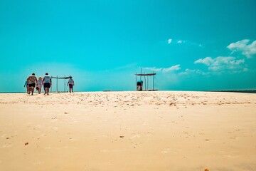 A group of tourists having fun at the sand bank of Funzi Island in Diani, Kenya