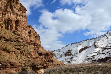 steep sandstone cliffs and snow- covered hillside on a sunny winter day  near  the ancient native american owl panel petroplyphs   in nine mile canyon, near wellington, utah