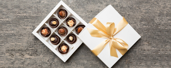 White box with chocolates candies and golden tape. top view with copy space