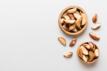 Fresh healthy Brazil nuts in bowl on colored table background. Top view Healthy eating bertholletia concept. Super foods