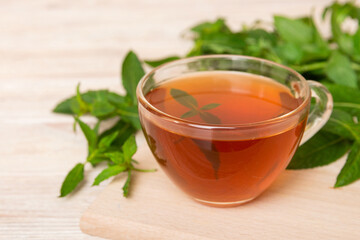 Cup of mint tea on table background. Green tea with fresh mint top view with copy space