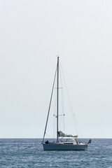 Obraz premium nearby sailing ship anchored in calm sea on bright day