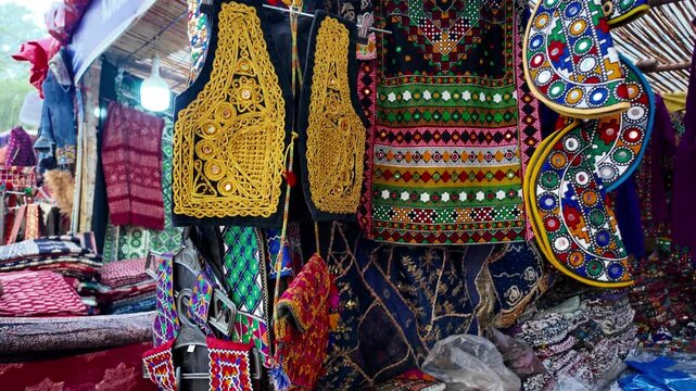 Cultural traditional attires with colorful ornated designs, displayed in a store in Loke Mela
