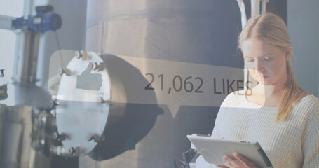 Using tablet, woman in industrial setting with 176,806 likes image over