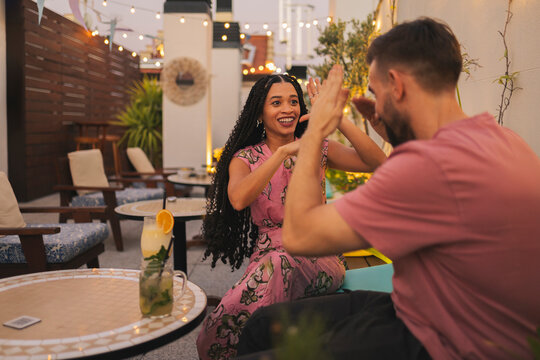 Happy woman gesturing and enjoying leisure time with boyfriend on terrace
