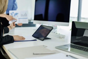 Young businesswoman adviser standing in front of laptop and giving advise to sales woman. Business people consulting at office. asian teamwork concept.

