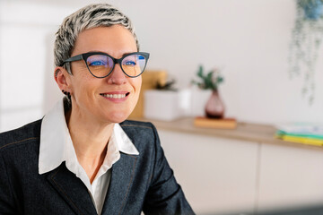 Businesswoman with short highlighted hair wearing eyeglasses at office