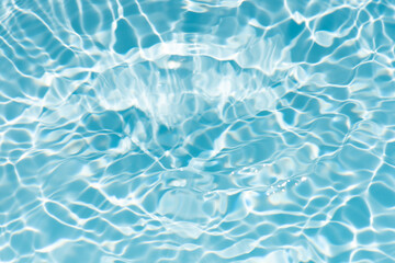 Blue water with ripples on the surface. Defocus blurred transparent blue colored clear calm water surface texture with splashes and bubbles. Water waves with shining pattern texture background.