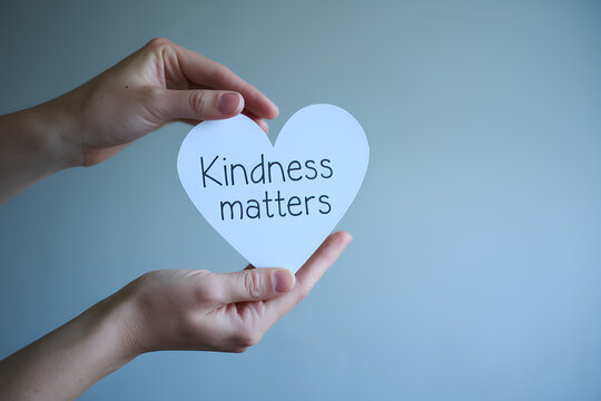 Kindness matters, hand holding a heart shape cutout