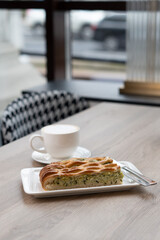 A piece of spinach pie on a plate on a table in a cafe