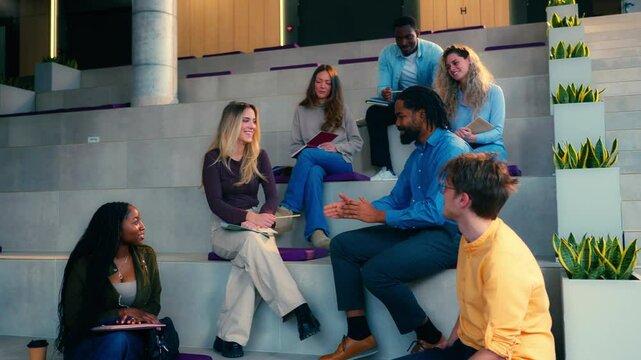 University students engaging in conversation, sharing ideas, and collaborating on projects in a modern university hall, captured in slow motion
