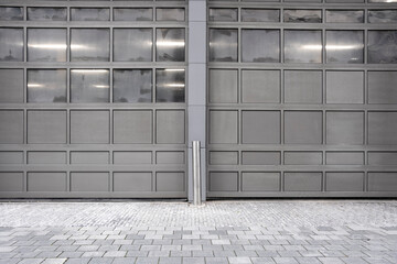 This image showcases two large, stylish garage doors that fit seamlessly into a modern urban environment, featuring sleek lines and a contemporary aesthetic.