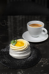 Meringue cake with lemon yellow cream and whipped cream on a white plate