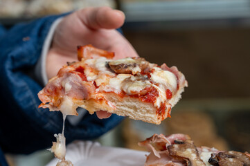Eating of Fresh baked bread focaccia or pala romana pizza with vegetables and cheese in bakery in Parma, Emilia Romania, Italy