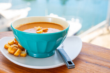 Homemade tasty fish or bisque soup with croutons and view on yacht boats and houses of Port...
