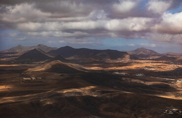 Vast desert landscape under a dramatic cloudy sky, showcasing the natural beauty