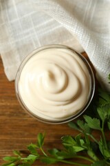 Bowl with mayonnaise on wooden background