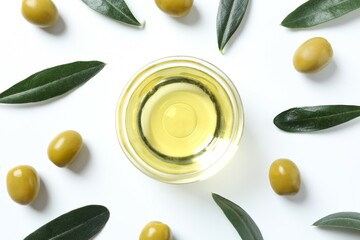 Bowl of fresh olive oil and olives with leaves on white background