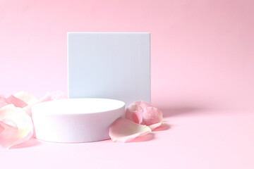 Pink rose petals with a podiums on a color background